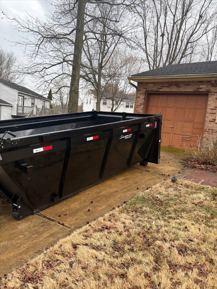 Roll-off dumpster delivered to a residential driveway